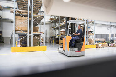 Worker on forklift in high rack warehouse - DIGF10589