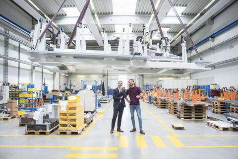Zwei Männer mit Hallenkran in einer Fabrik, lizenzfreies Stockfoto
