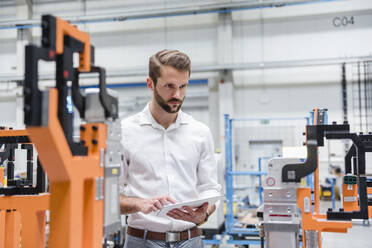 Man using tablet on factory shop floor - DIGF10613