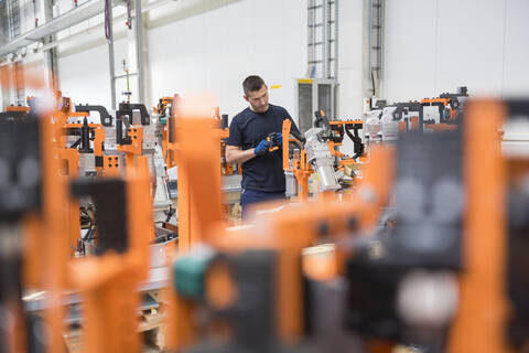 Mann arbeitet an einer Maschine in einer Fabrik, lizenzfreies Stockfoto