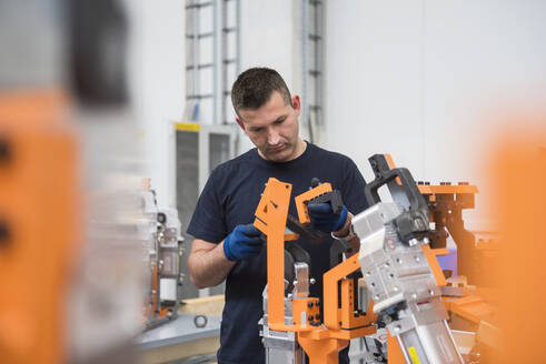 Mann arbeitet an einer Maschine in einer Fabrik - DIGF10644