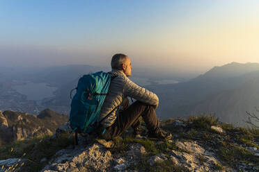 Hiker sitting on viewpoint, Orobie Alps, Lecco, Italy - MCVF00306