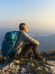 Hiker sitting on viewpoint, Orobie Alps, Lecco, Italy - MCVF00307