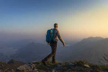 Rear view of hiker on mountaintop, Orobie Alps, Lecco, Italy - MCVF00312