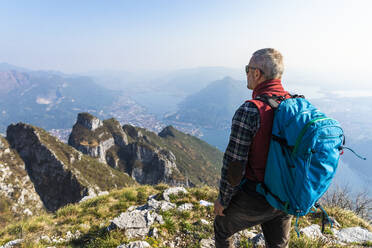 Rückansicht eines Wanderers auf einem Berggipfel, Orobie Alpen, Lecco, Italien - MCVF00317