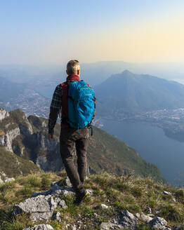 Rückansicht eines Wanderers auf einem Berggipfel, Orobie Alpen, Lecco, Italien - MCVF00321