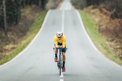 Young sportsperson cycling on road - MTBF00394