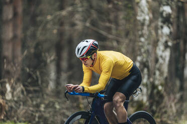 Junger Mann in Sportkleidung fährt Fahrrad - MTBF00397