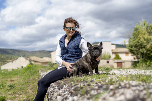 Porträt einer Frau und ihrer Bulldogge im Freien sitzend, Castilla La Mancha, Spanien - OCMF01210