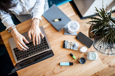 Crop-Ansicht einer jungen Frau, die zu Hause am Laptop arbeitet, Ansicht von oben - DAWF01446