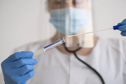 Woman in protective wear taking a covid-19 swab - SNF00114