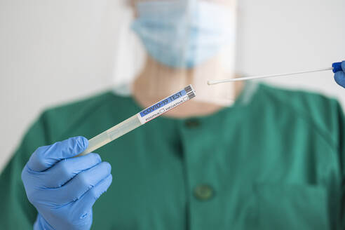 Woman in protective wear taking a covid-19 swab - SNF00120