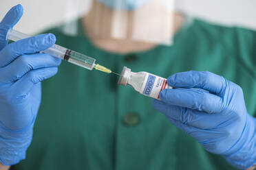 Woman in protective wear preparing covid-19 vaccination - SNF00123