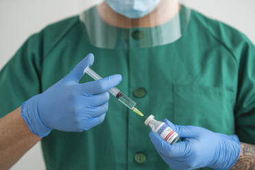 Man in protective wear preparing covid-19 vaccination - SNF00132