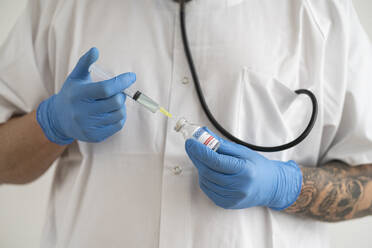 Man in protective wear preparing covid-19 vaccination - SNF00139