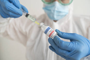 Woman in protective wear preparing covid-19 vaccination - SNF00148