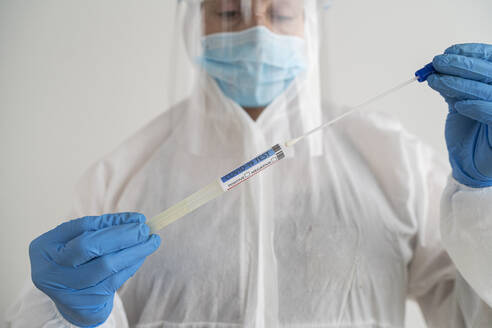 Woman in protective wear taking a covid-19 swab - SNF00153