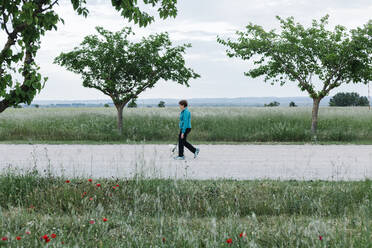 Ältere Frau geht mit ihrem Hund auf dem Lande spazieren - XLGF00146