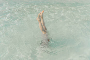 Beine einer Frau in einem Pool - ERRF03720
