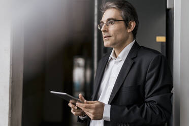 Mature businessman holding tablet in a factory - DIGF10655