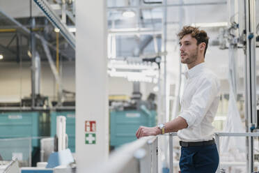 Young businessman standing in a factory - DIGF10726
