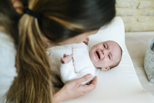 Mutter schaut auf ihr weinendes Baby - KIJF03008