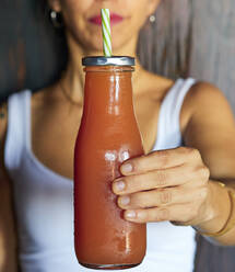 Frauenhand hält Glasflasche mit frischem Fruchtsaft, Nahaufnahme - VEGF02163