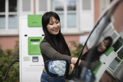 Carsharing, Frau mietet ein Elektroauto - SGF02633