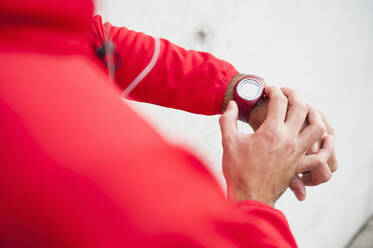 Close-up of man adjusting his smartwatch - DIGF10785