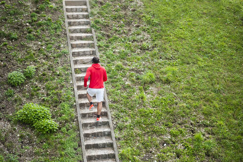 Junger Mann läuft die Treppe hinauf - DIGF10816