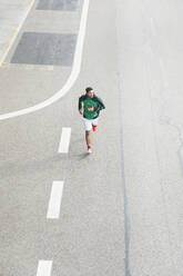 Bird's eye view of young man running on a road - DIGF10822