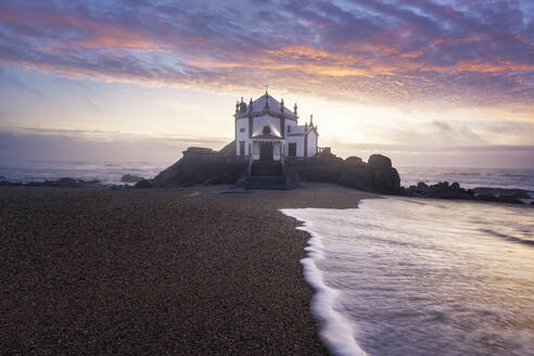 Portugal, Porto District, Vila Nova de Gaia, Long exposure of Praia de Miramar and Capela do Senhor da Pedra at moody sunset - RPSF00314