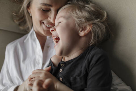 Nahaufnahme eines blonden Jungen, der seine Freizeit mit seiner Mutter zu Hause genießt, lizenzfreies Stockfoto