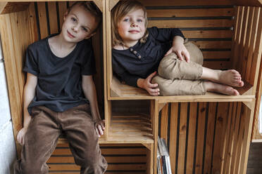 Porträt von in Holzkisten sitzenden Jungen - OGF00413