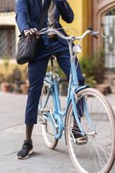 Crop-Ansicht von Geschäftsmann fahren hellblau Vintage Fahrrad - EGAF00074