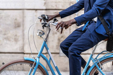 Crop-Ansicht von Geschäftsmann fahren hellblau Vintage Fahrrad - EGAF00078