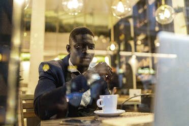 Porträt eines jungen Geschäftsmannes, der in einem Café an einem Laptop arbeitet - EGAF00083