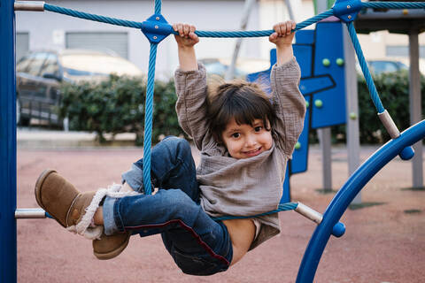 Mädchen auf Kletternetz in Spielplatz, lizenzfreies Stockfoto