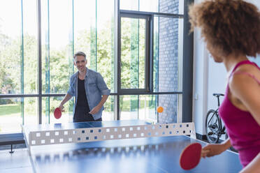 Young business people plaing table tennis in loft office - DIGF10850