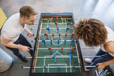 Junge Geschäftsleute spielen in ihrer Mittagspause Fußball - DIGF10870