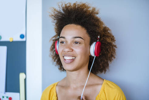 Lachende junge Frau mit Kopfhörern - DIGF10884