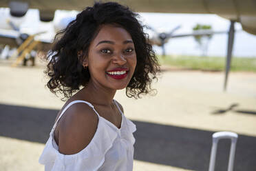 Seitenansicht Porträt der lächelnden jungen Frau auf dem Flughafen Landebahn stehen - VEGF02191