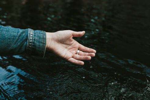 Deutschland, Junge Frau macht Hand im Teich nass - VBF00031