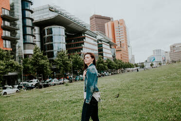 Germany, Berlin, Portrait of young woman posing outdoors in denim jacket - VBF00037