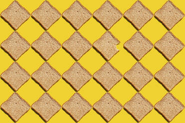Muster von Weizenbrotscheiben vor gelbem Hintergrund - GEMF03723