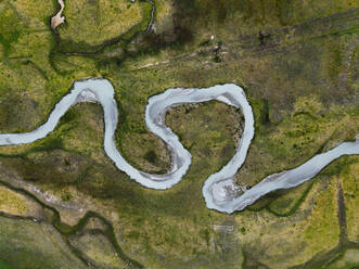Luftaufnahme eines gewundenen Flusses, der Sedimente vom Gletscher mit sich führt, Preda Rossa Tal, Val Masino, Italien. - AAEF08347