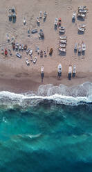 Luftaufnahme von vielen Booten an Land, während das Meer rau ist, San Sostene, Kalabrien, Italien. - AAEF08348