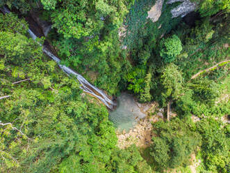 Luftaufnahme des dünnen und hohen Montpeller-Wasserfalls, der in ein Becken inmitten des dichten Dschungels auf der Insel Cebu, Philippinen, hinabfließt. - AAEF08421