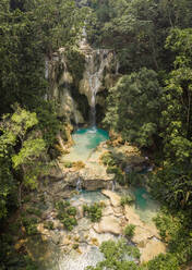 Luftaufnahme der berühmten Touristenattraktion Kuang Si-Wasserfälle, die wunderschöne Kalksteinbecken zwischen üppigen Bäumen zeigen. Luang Prabang, Laos - AAEF08426