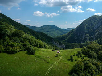 Aerial view of setting up camp for the night in the mountains around the deep cave system of Cheile Varghisului, Harghita, Romania - AAEF08428